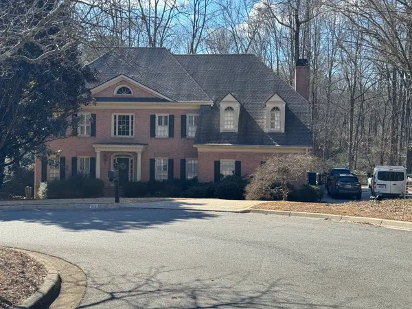 Two-story pink-brick colonial with white trim and dark shutters