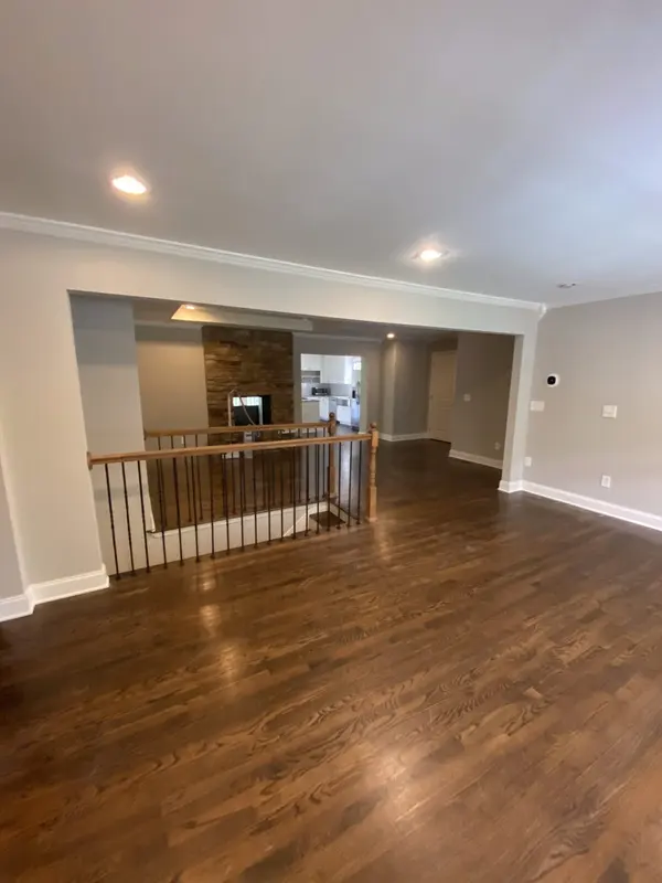 Open living area with dark refinished hardwood, gray walls and a stair rail