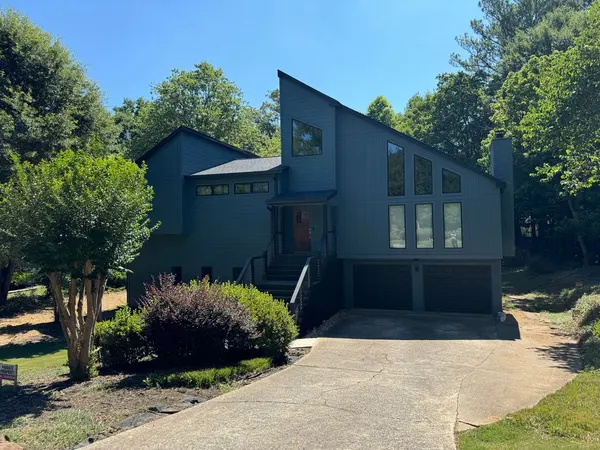 Contemporary home painted slate blue with dark trim, tall windows and a double garage