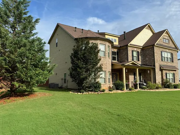 Brick and tan siding two-story home with a turret bay and covered porch