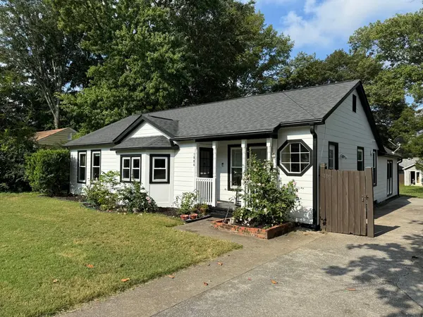 White painted ranch home with black window trim, an octagon window and a wood side gate