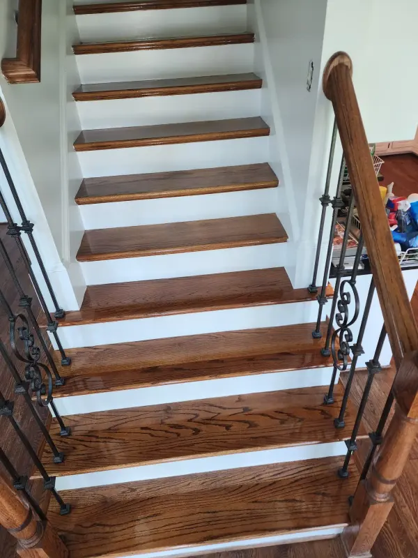 Staircase with stained oak treads, white risers and black iron balusters