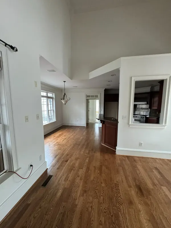 Refinished medium-brown oak floor through an open living room and kitchen