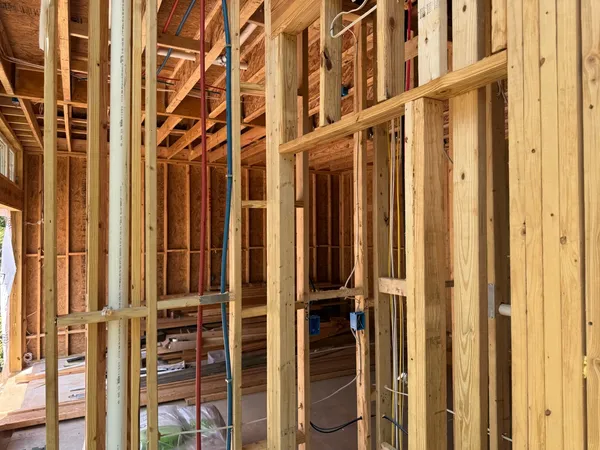 Framing detail with plumbing stack and wiring run before boarding