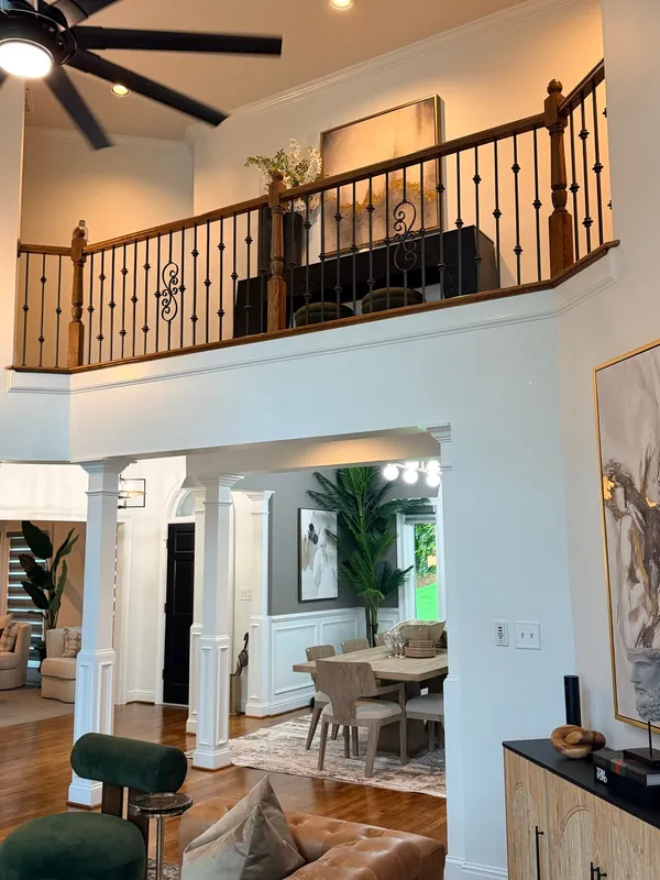 Timber and iron balcony rail above an arched opening, white trim throughout