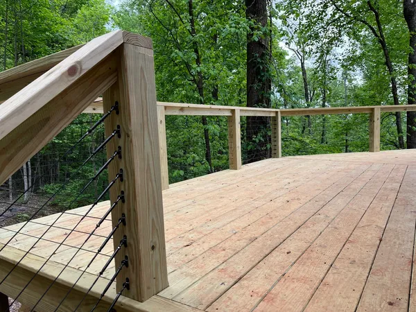 Cable railing post detail on a newly built pressure-treated deck