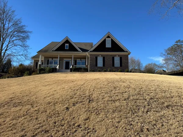 Brick and siding ranch home with a covered porch seen across a dry front slope