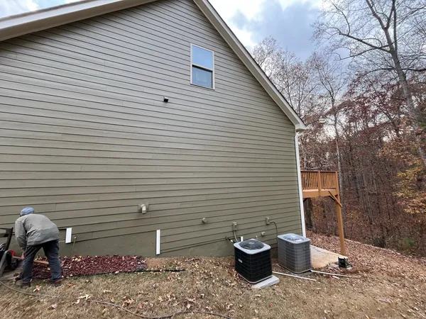 Tan lap siding gable end with condenser units at the base