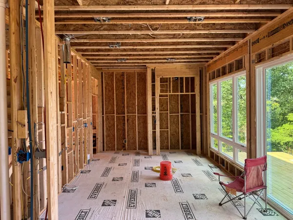 Framed room opened up to new windows, sheathing on and floor protection down